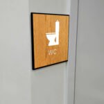 Taktilt piktogram trä med ram WC
