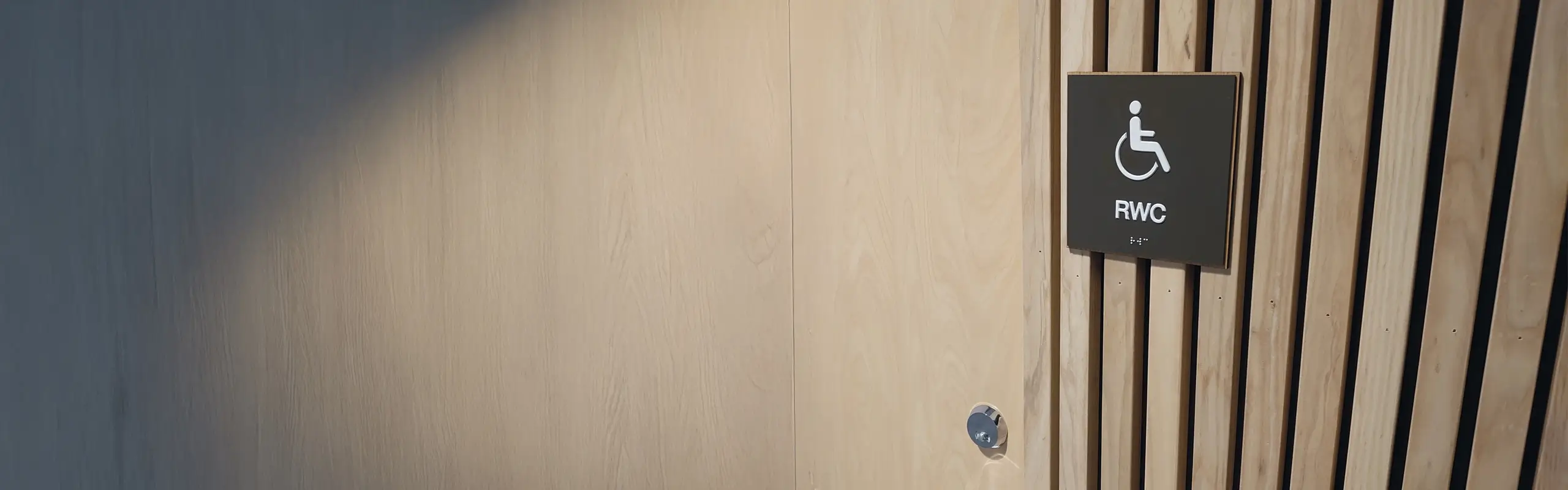 Taktil skylt på en trävägg